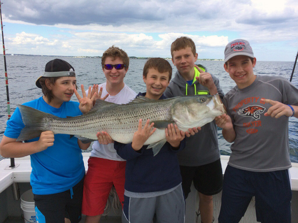 Kids holding up their big striped bass