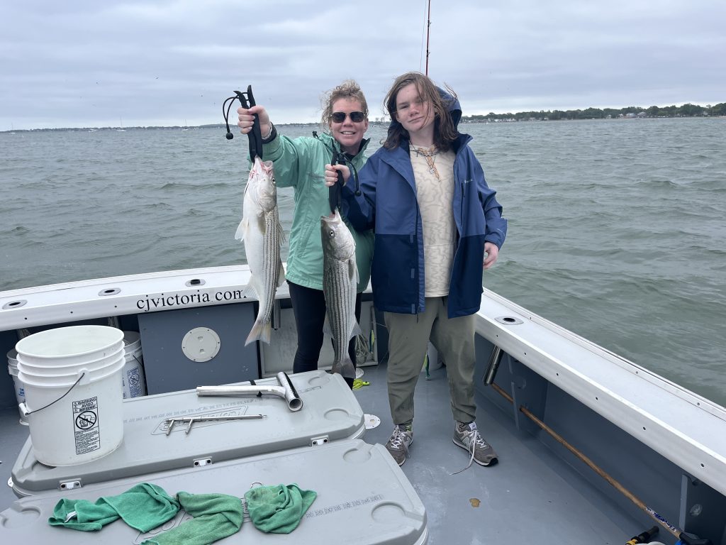 Boston Striped Bass. Mom and son showing holding striped bass. 